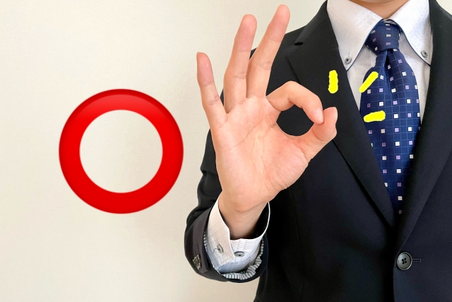 OKの手をするスーツ姿の男性